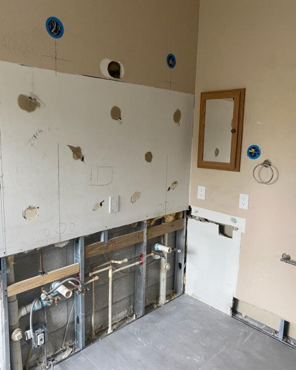 Bathroom with open walls showing new electrical boxes and outlets during rough-in